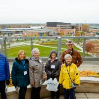 six people smiling on balcony of library